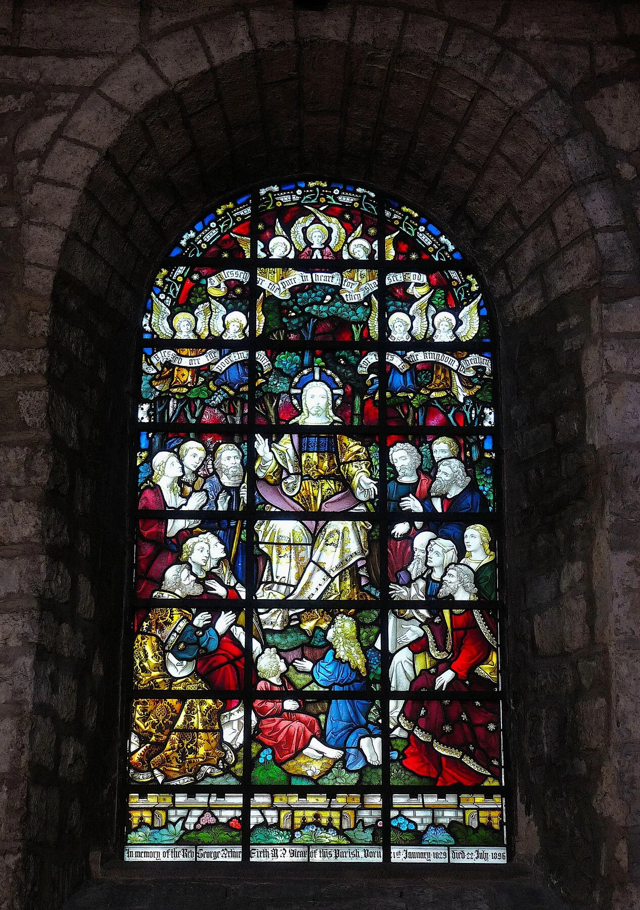 Richly coloured window showing Christ preaching to a crowd on a hillside